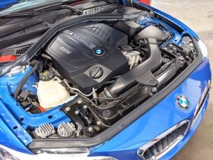 BMW M235i with its hood open in the shop at Eurospec Autowerks.