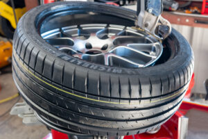 Michelin tire getting mounted with leverless scratch free Coats tire machine.